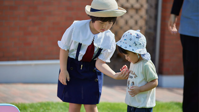 校庭で乳幼児と触れ合うキンダースクール和歌山の生徒